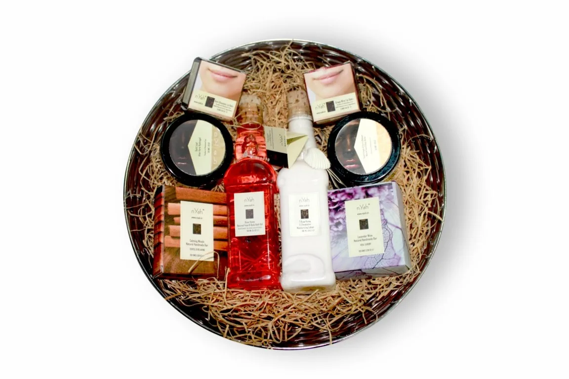 Nyah Round Basket Gift – Best of Nyah (190 ml), Round woven-look basket with filler and assorted bottles, boxes and round containers.